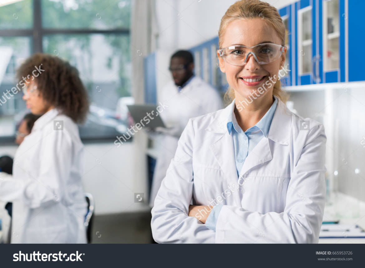 stock-photo-portrait-of-smiling-woman-in-white-coat-and-protective-eyeglasses-in-modern-laboratory-female-665953726.jpg