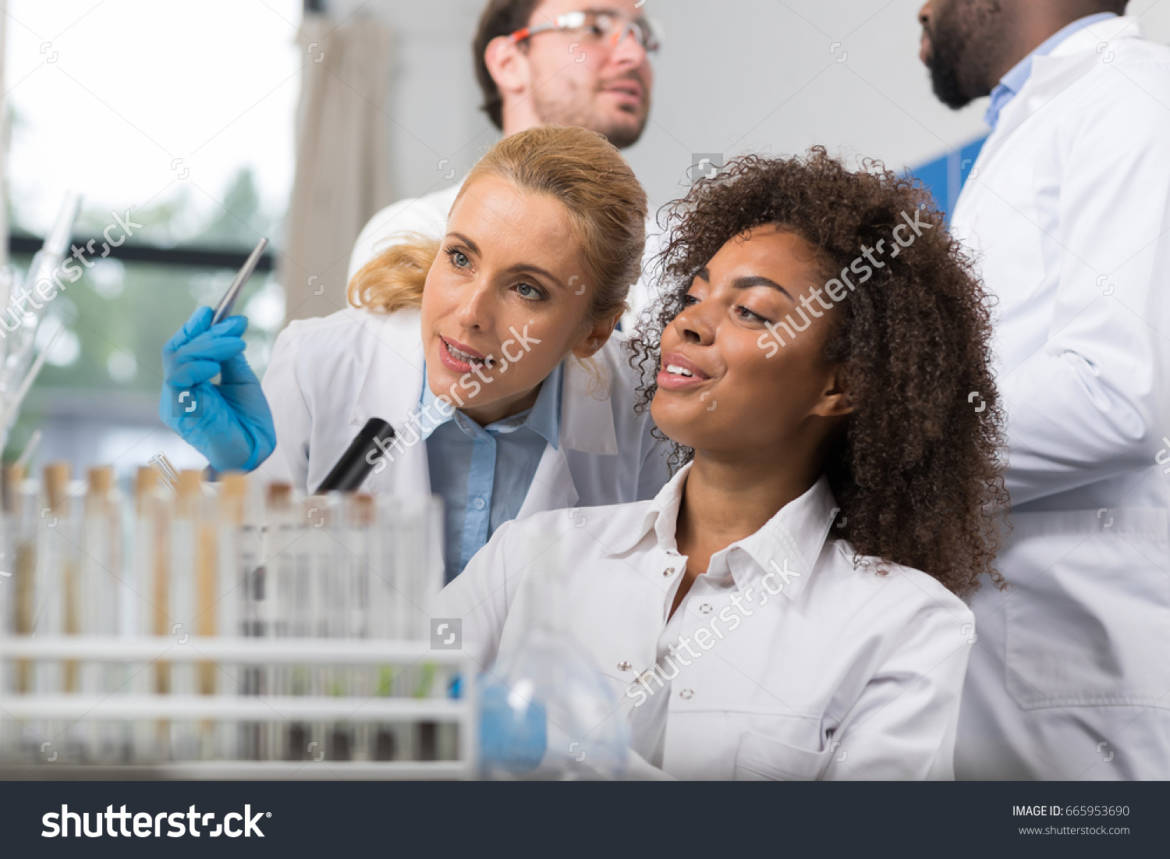 stock-photo-two-female-scientist-examine-sample-working-in-modern-laboratory-group-of-researchers-making-665953690.jpg