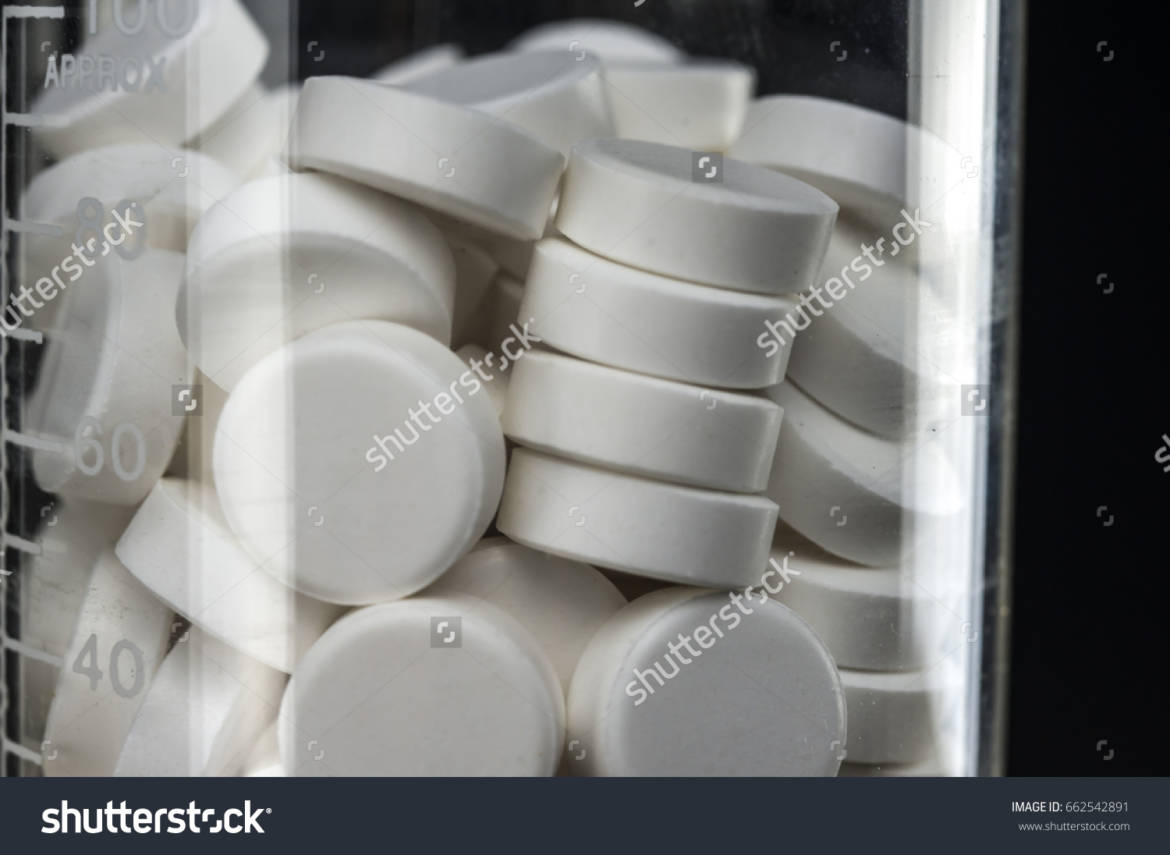stock-photo-white-pill-tablets-in-chemistry-beaker-close-up-662542891.jpg