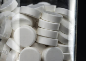 White Tablets in Chemistry Beaker